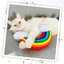 A fluffy white cat snuggling the rainbow-shaped catnip toy on a gray couch, looking at the camera.