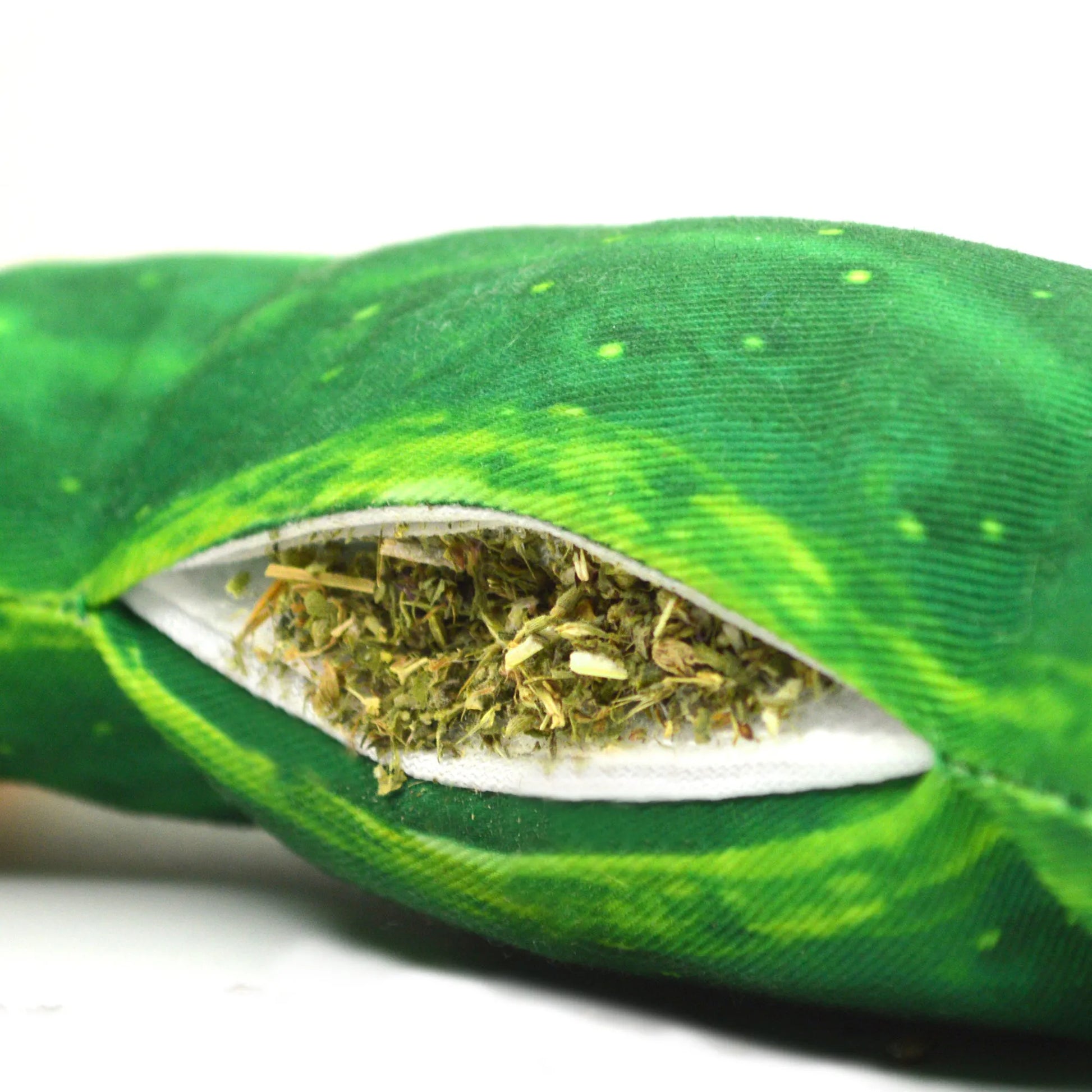 Close-up of the pickle toy’s refillable pocket, showing loose catnip securely packed inside the green fabric.