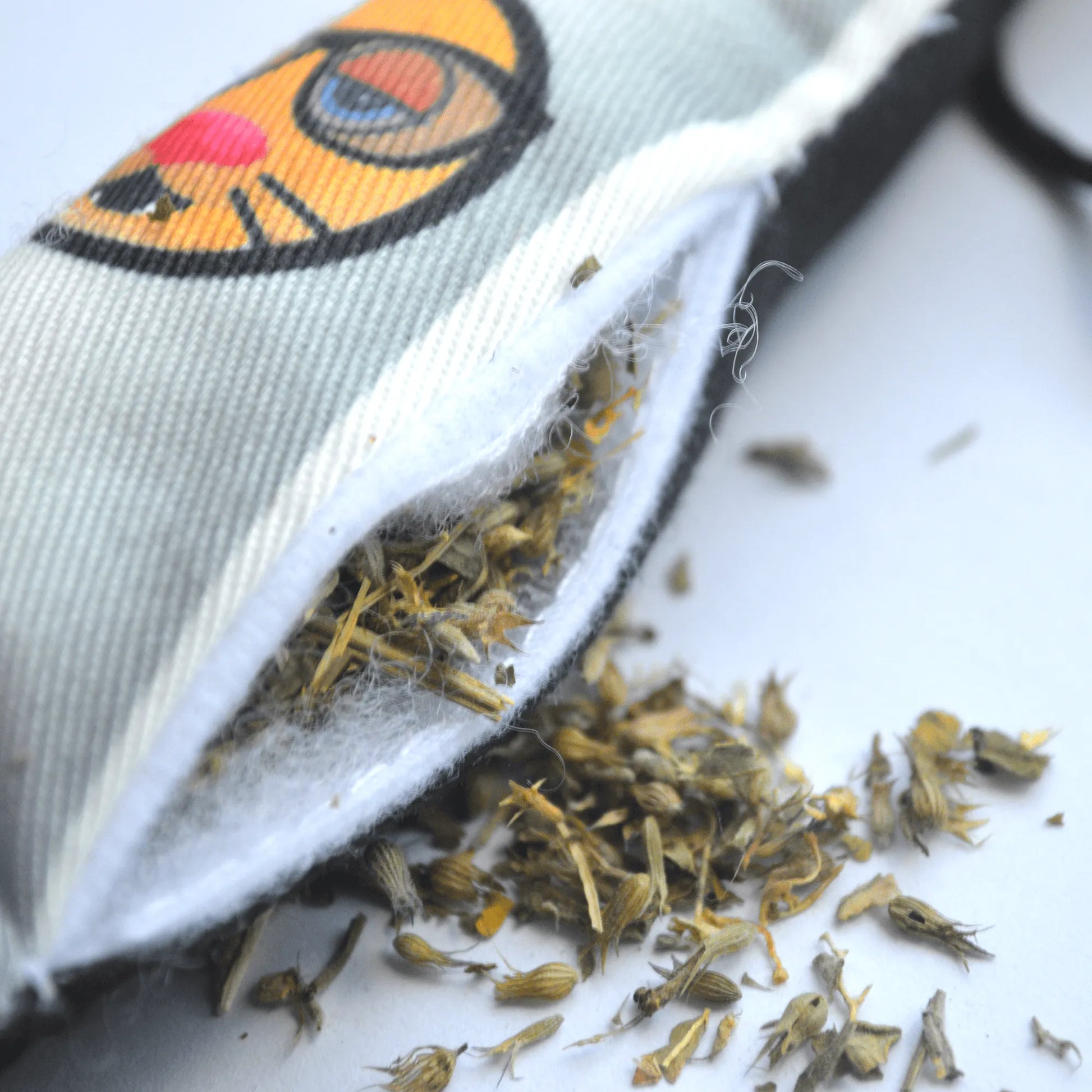 Close-up of the refillable rocket toy showing premium catnip spilling out from its interior pocket.