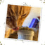 Orange cat licking from an open jar of Kalico Kush catnip, enjoying the scent and taste.