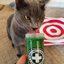 Gray cat licking the Meowi-Waui container while looking focused and interested in the catnip.